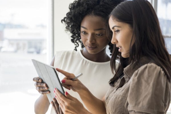 Young multi racial women looking at device with serious expression